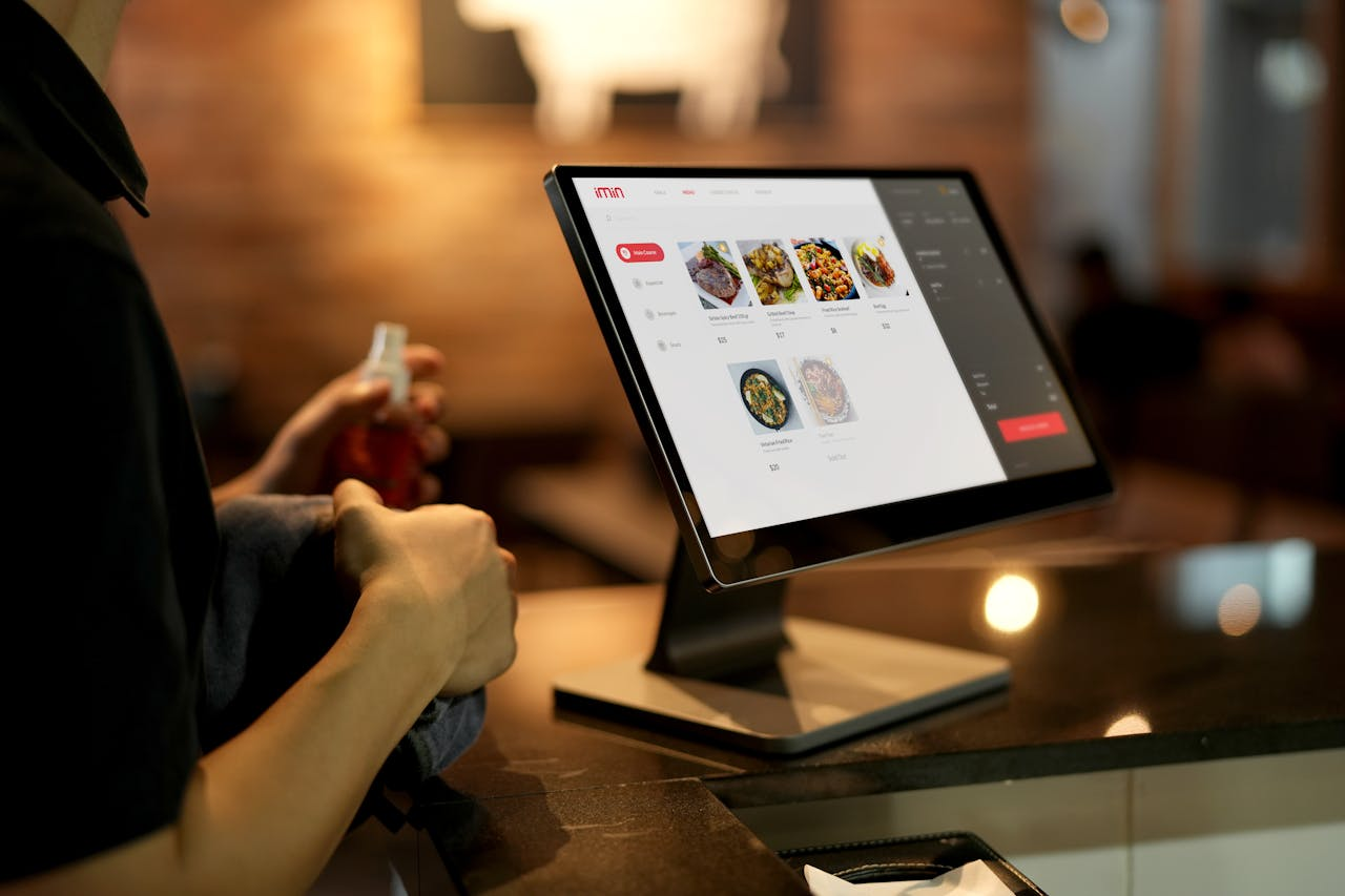 A person using a touchscreen ordering system in a modern restaurant setting.